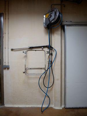 une photo d'un garage avec un souffleur et un tuyau d'arrosage