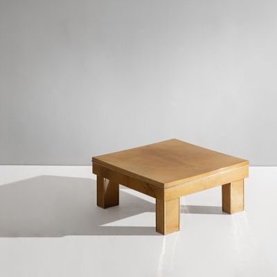 une table basse en bois posée sur une surface blanche, avec un mur gris en arrière-plan