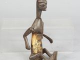 statue of a man sitting on the ground with his legs crossed