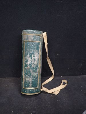 une boîte verte munie d'une lanière, posée sur une surface noire