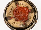 a red wax seal sitting on top of a metal object
