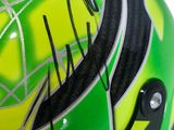 the helmet of person, driver of the green and yellow race car