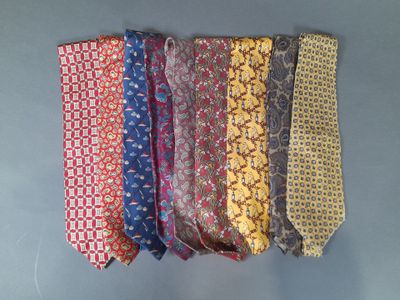 several different colored ties are lined up on a gray surface