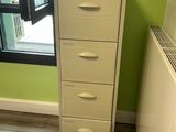 an image of a room with a green wall and a white filing cabinet