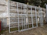 a metal fence that is leaning against a concrete wall