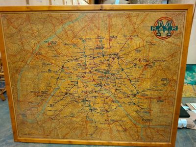 Une vieille carte de Paris est exposée dans un cadre en bois.