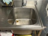 a sink in the kitchen with a basket of cleaning supplies