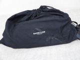 a black bag with a logo on it sitting on a bed