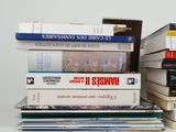 many books stacked on top of each other on a table