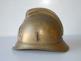 a gold fireman ' s helmet sitting on a white table