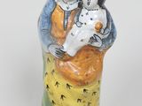 une figurine représentant une femme tenant un enfant et un chien dans ses bras