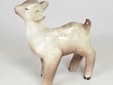 a small ceramic animal that is standing on a white surface