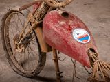 a dirty bike with a red tank attached to it