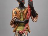 an image of a statue of a man holding a flower