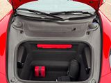 a red car with its trunk open and luggage in the trunk