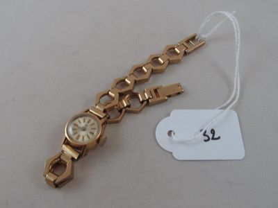 a gold wrist watch with a white dial on it