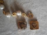 a necklace with a picture of an owl and a pearl bead