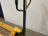 a fork lifter sitting on the floor next to a wall