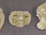 three carved heads of a man and a woman on a table