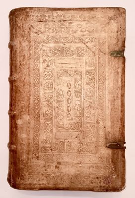 an old book sitting on top of a white table next to a white wall