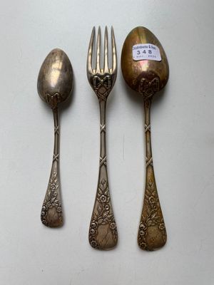 three spoons, a fork and a spoon on a white surface