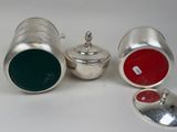 a silver container with a red lid and a silver container with a green lid and a silver container with a red lid and a silver container with a green