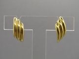 boucles d'oreilles plaquées or au motif ondulé, présentées sur un présentoir en acrylique transparent