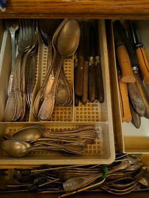 un tiroir rempli d'argenterie et de cuillères dans une cuisine