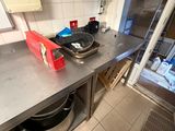 Il y a quelqu'un dans la cuisine avec une casserole et une poêle posées sur le plan de travail.