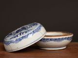 a blue and white bowl with a lid sitting on a table
