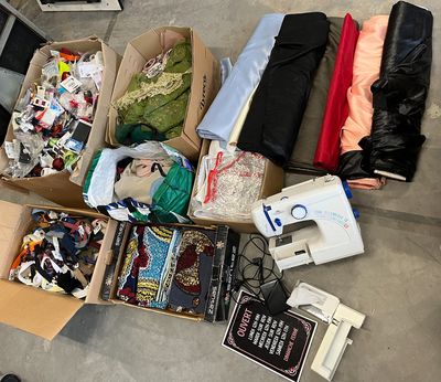 many boxes of clothing and a sewing machine on the floor