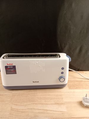 un grille-pain posé sur une table, dont le cordon d'alimentation est branché