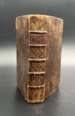 an old book sitting on top of a table next to a black background