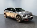 the silver suv is parked in a showroom with a black floor