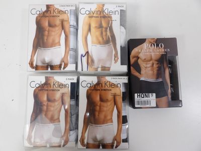 Quatre sous-vêtements pour hommes sont exposés sur une table blanche