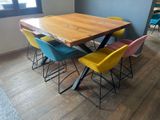 brightly colored chairs sit around a wooden table in a room