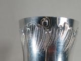 a person holding a silver ring with wings on it