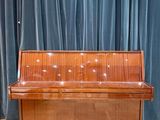 a piano that is sitting in front of a blue curtain