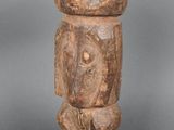 un gros plan d'une statue en bois posée sur une surface grise