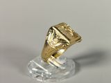a gold ring that is sitting on a clear stand