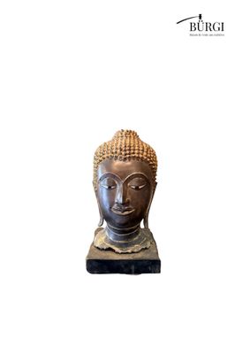 statue of a buddha head on a stand on a white background