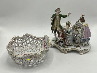 three porcelain figurines of people and a basket on a table