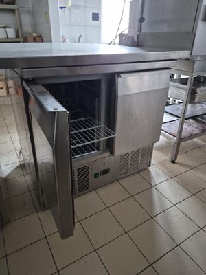 une table en acier inoxydable avec une porte ouverte dans une cuisine