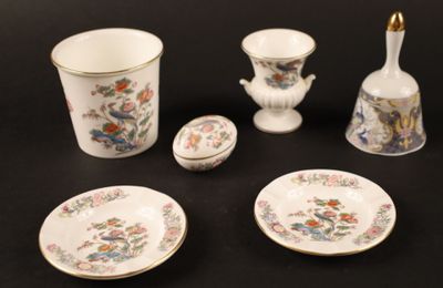 quatre pièces de vaisselle sur une table, avec un vase, un bol et une assiette