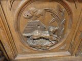 a carved wood panel with a bird and flowers on it