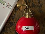 a red lamp on a table next to a book