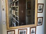 un miroir accroché au mur au-dessus d'une table sur laquelle sont posées des photos