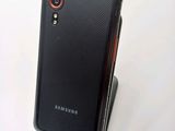 the back of a black cell phone with a red ring on it