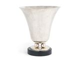un vase ancien en argent avec un socle noir sur fond blanc