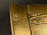 a close up of a gold plate with a handle on it